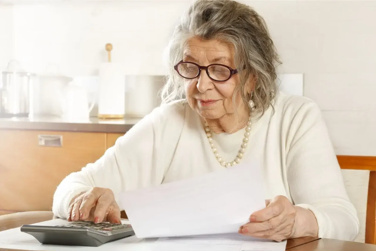Důchodkyně si kontroluje výši svého důchodu.