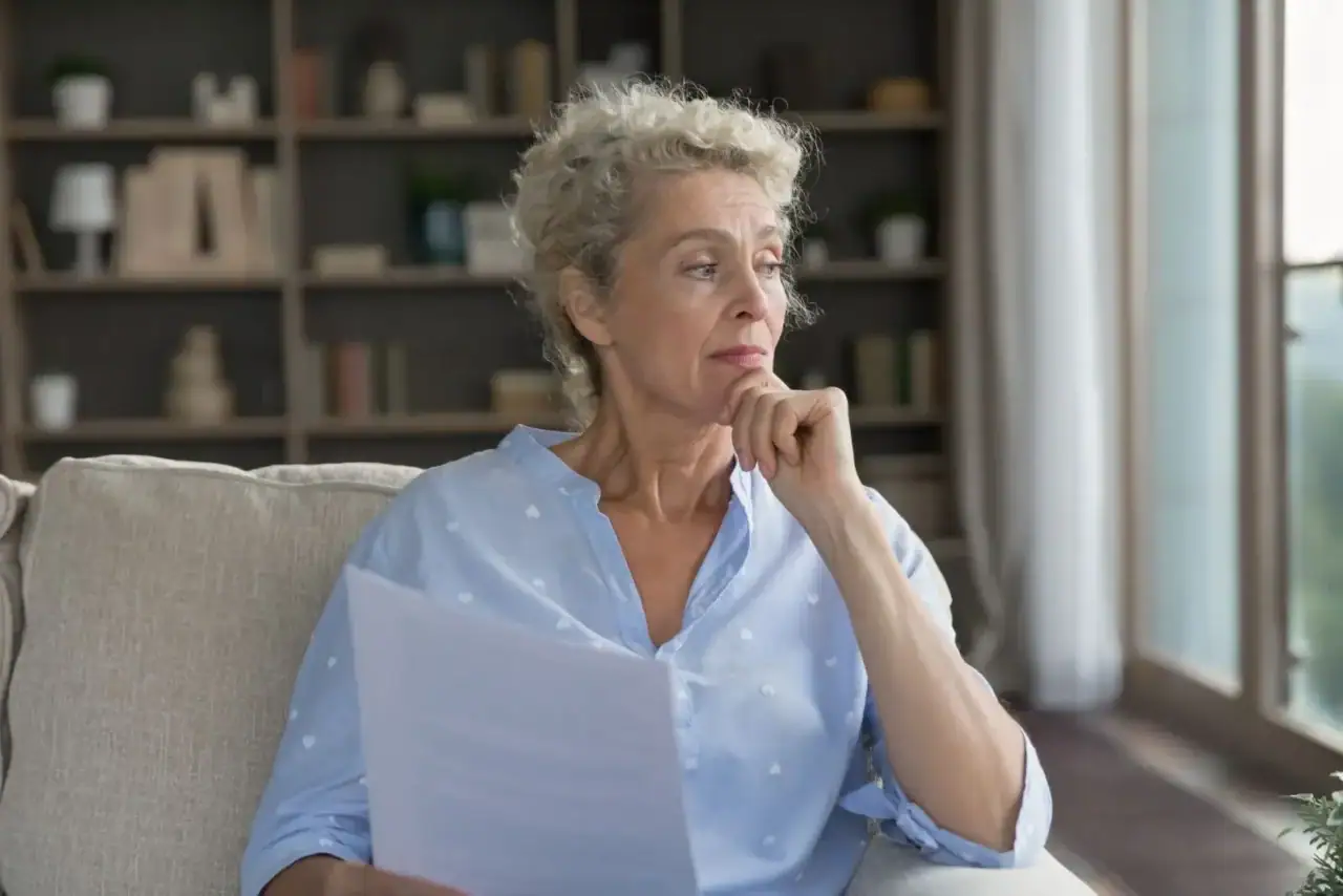 Čerstvá důchodkyně si studuje rozhodnutí úředníků.