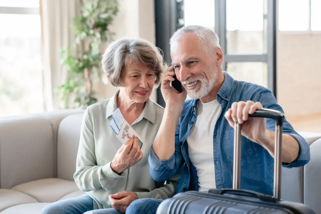 Manželé v důchodu odjíždějí na zahraniční dovolenou.