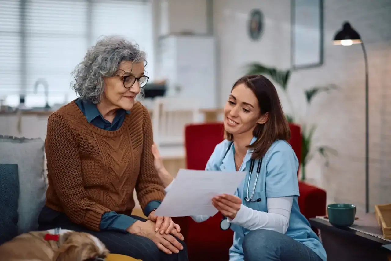 Seniorka řeší s pracovnicí zařízení podmínky pobytu a potřebné dokumenty.