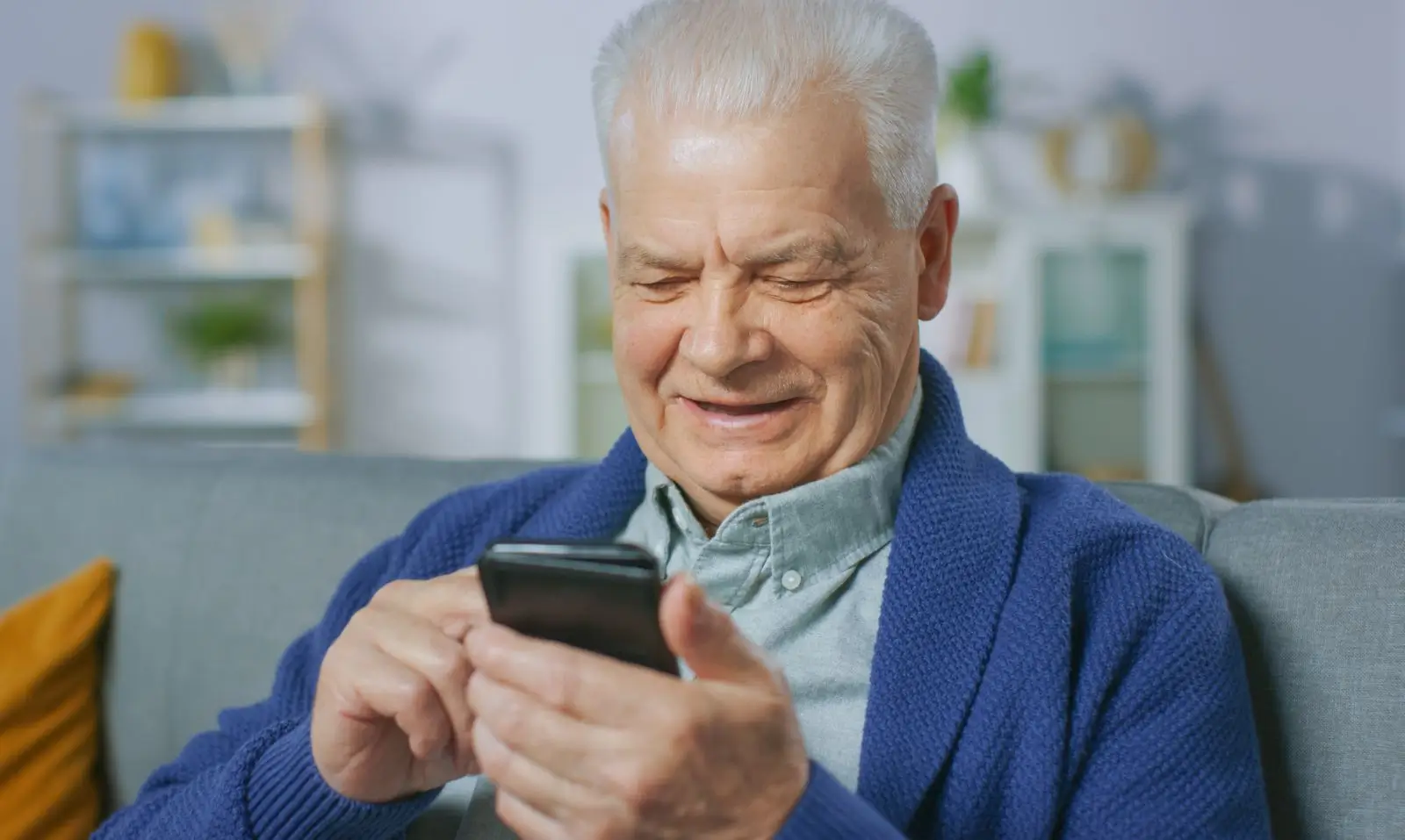 Senior pracuje s jednoduchým telefonem.