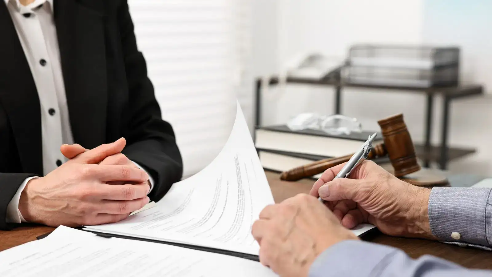 Senior podepisuje insolvenční návrh u právníka.