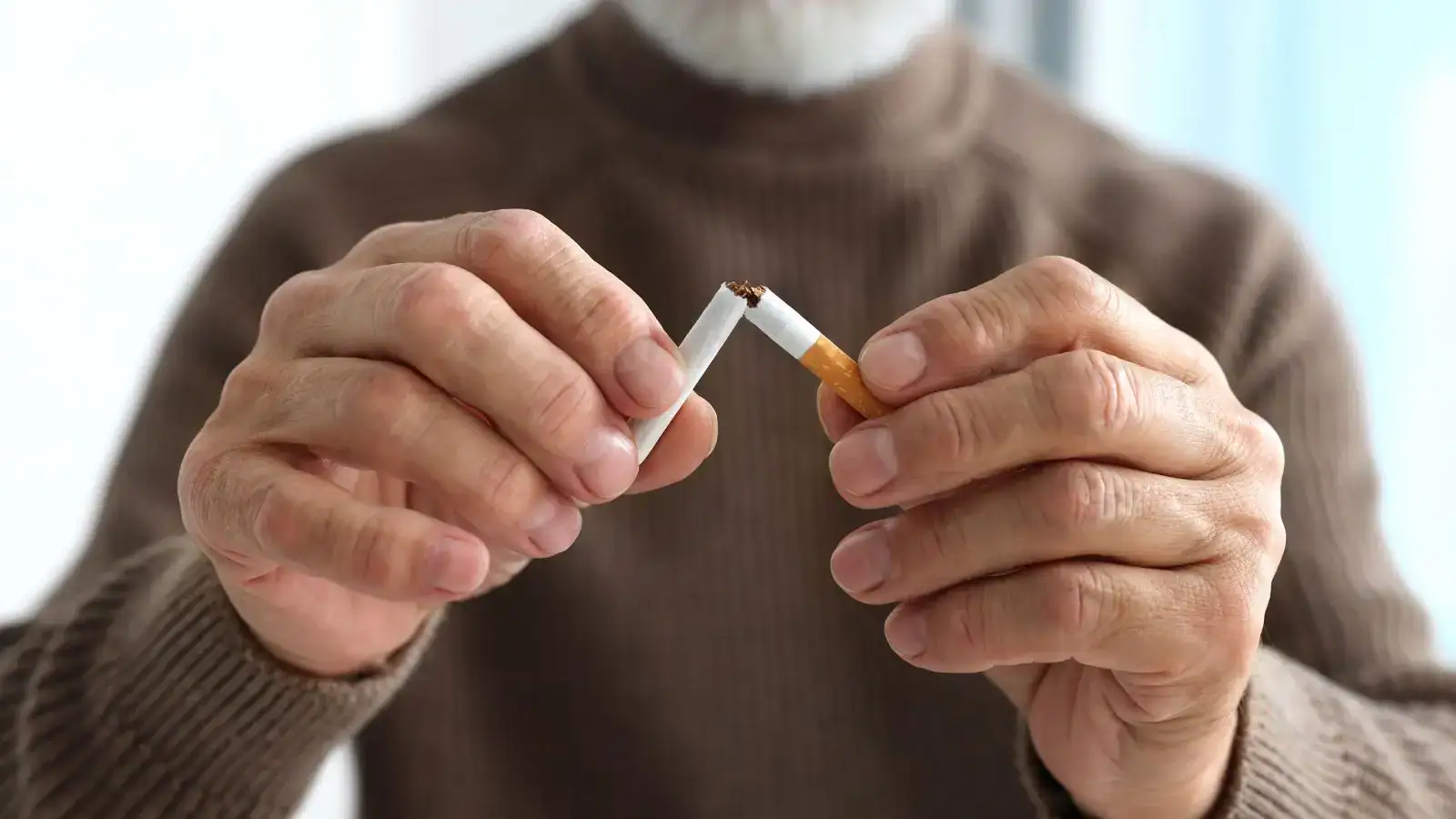 Senior láme cigaretu v rámci odvykání kouření.